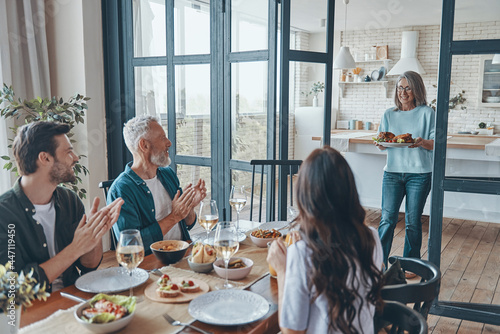 Happy multi-generation family smiling while having dinner together