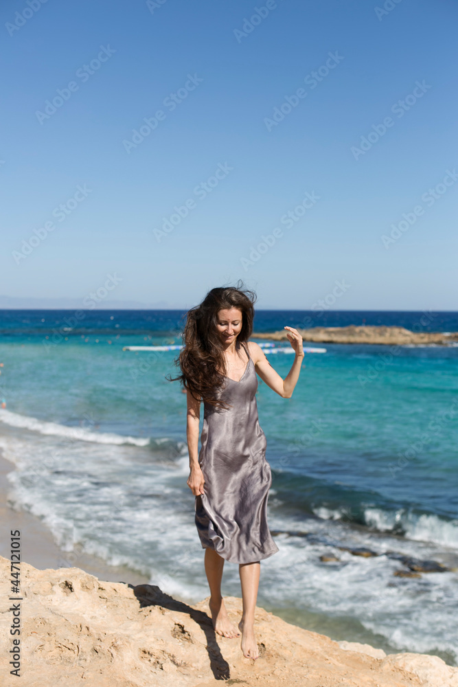 Photo of a young and attractive woman walking on the beach Photo of a young and attractive woman walking on the beach