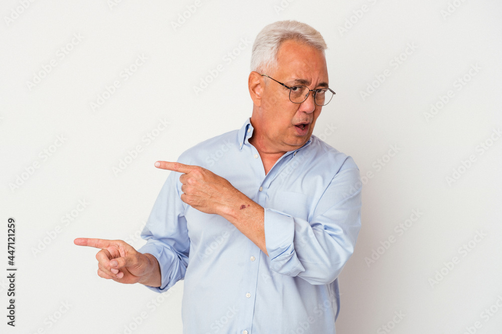Senior american man isolated on white background pointing with forefingers to a copy space, expressing excitement and desire. Senior american man isolated on white background pointing with forefingers to a copy space, expressing excitement and desire.