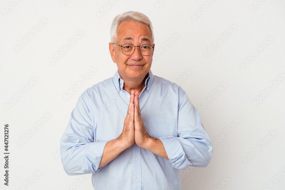 Senior american man isolated on white background holding hands in pray near mouth, feels confident. Senior american man isolated on white background holding hands in pray near mouth, feels confident.