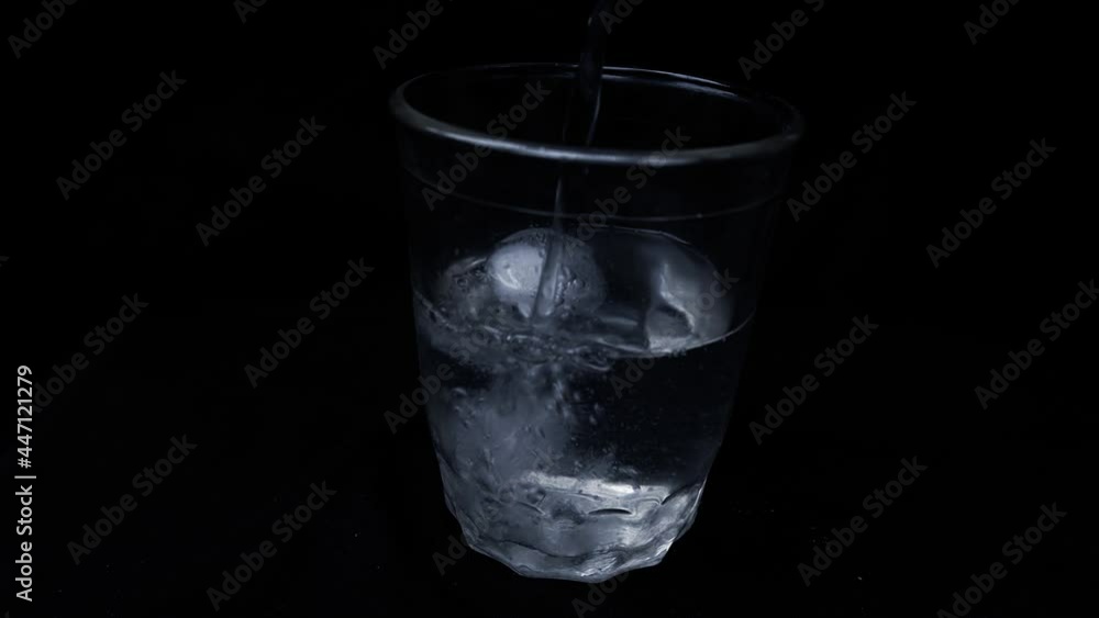 Pour water into a glass with ice Pour water into a glass with ice