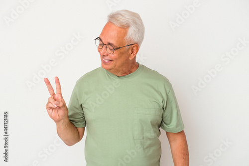 Senior american man isolated on white background joyful and carefree showing a peace symbol with fingers.