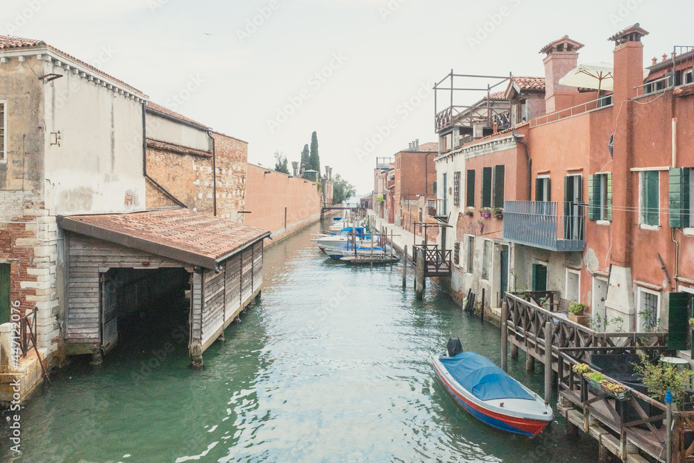 Narrow canal by traditional Venetian houses on island of Giudecca, Venice, Italy