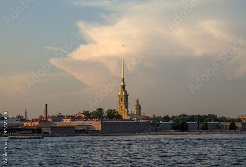 Saint Petersburg, RUSSIA-July, 15, 2021: view of the yellow tower with the spire of the Peter and Paul Fortress and the Neva River on a summer day and a space for copying © Inna