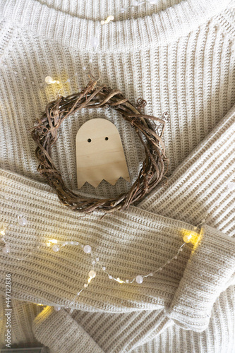 a Halloween ghost made of wood, knitting, a wreath of vines