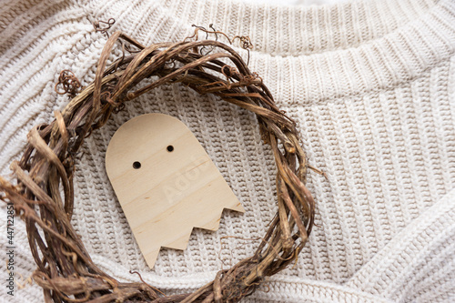 a Halloween ghost made of wood, knitting, a wreath of vines