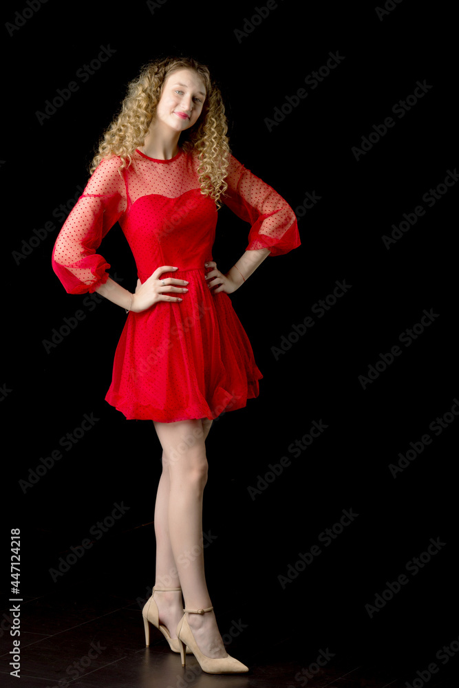 Smiling blonde curly girl posing in red dress Smiling blonde curly girl posing in red dress