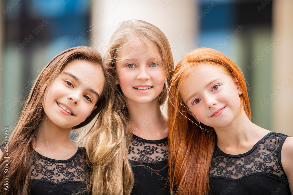 Portrait of three teenage girls with loose hair, blonde, redhead and brunette Summer on street. Vloses develop in wind. Portrait of three teenage girls with loose hair, blonde, redhead and brunette Summer on street. Vloses develop in wind.