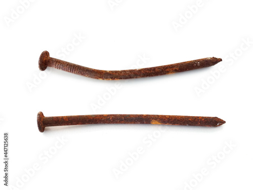 Aerial view of two rusty nails in horizontal position isolated. Close up of old wry rusty nail shot from above on white. Hardware store object.