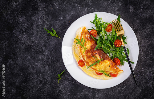 Breakfast. Omelette with tomatoes, cheese and salad on white plate. Frittata - italian omelet. Top view