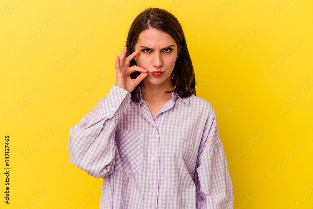 Young caucasian woman isolated on yellow background with fingers on lips keeping a secret. Young caucasian woman isolated on yellow background with fingers on lips keeping a secret.
