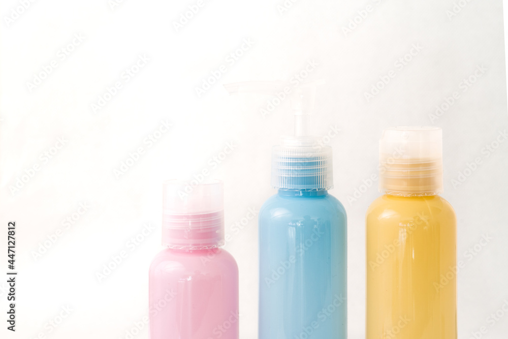jars with blue, pink and yellow cosmetics on white background jars with blue, pink and yellow cosmetics on white background