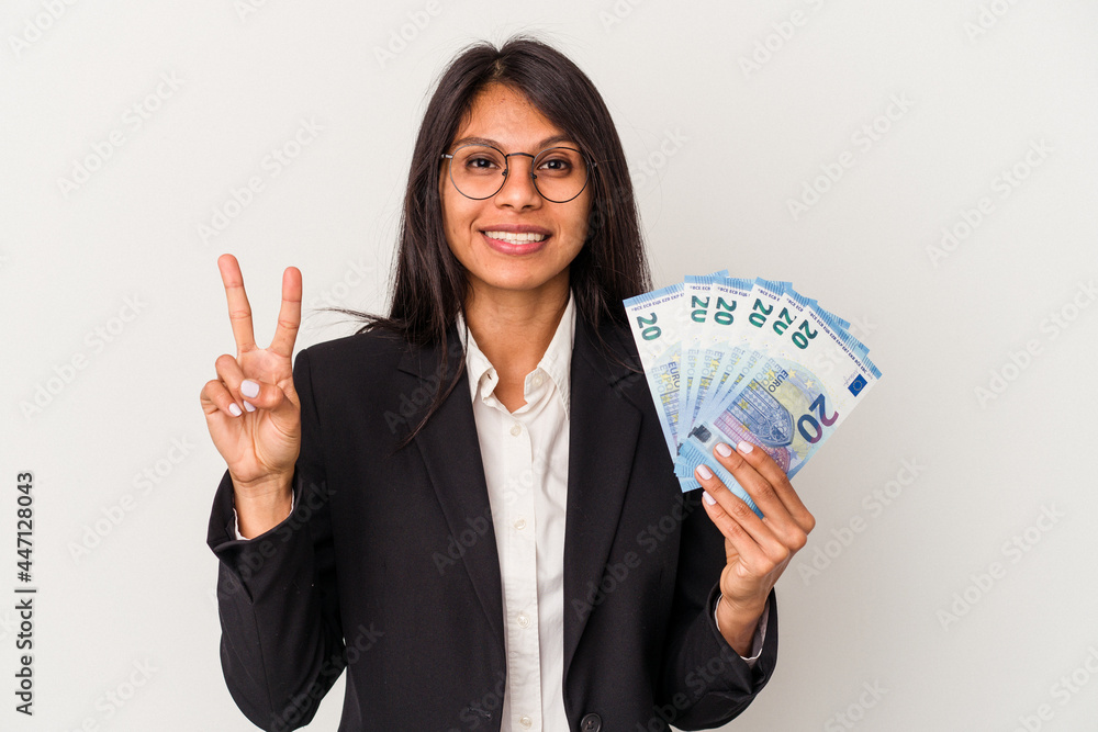 Young business latin woman holding bills isolated on white background showing number two with fingers. Young business latin woman holding bills isolated on white background showing number two with fingers.