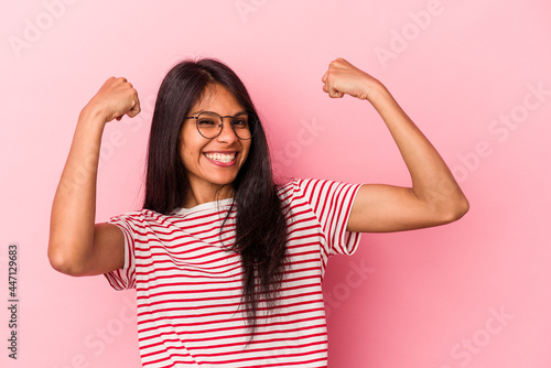 Young latin woman isolated on pink background cheering carefree and excited. Victory concept.