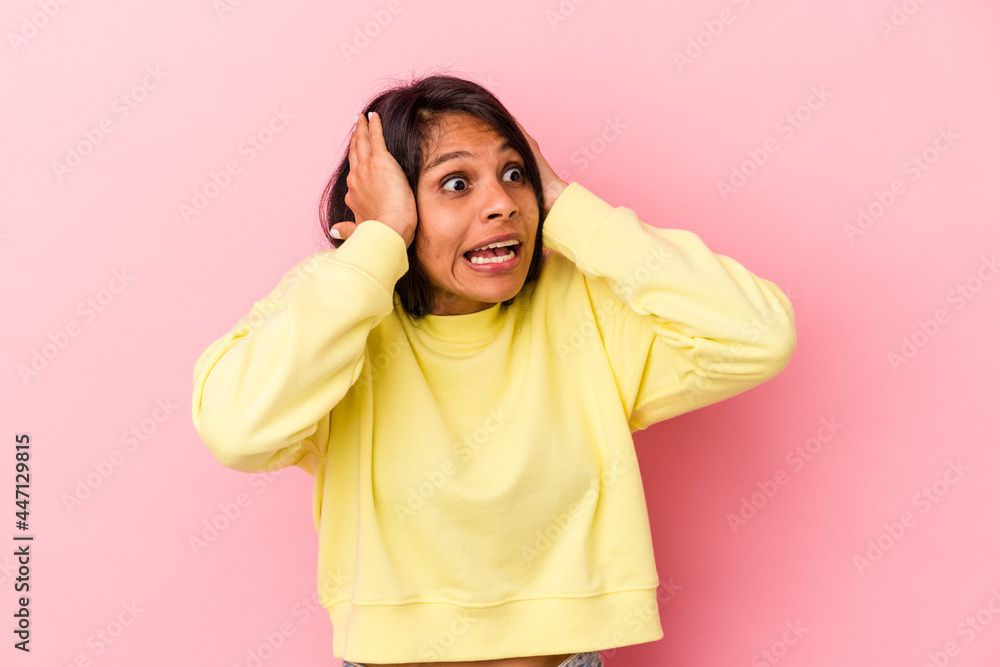Young latin woman isolated on pink background screaming, very excited, passionate, satisfied with something. Young latin woman isolated on pink background screaming, very excited, passionate, satisfied with something.