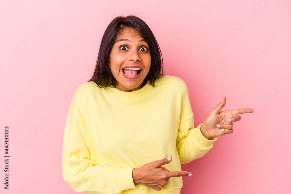 Young latin woman isolated on pink background excited pointing with forefingers away. Young latin woman isolated on pink background excited pointing with forefingers away.