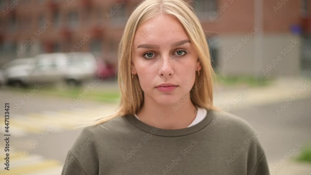 Close-up of a smoking woman in the city. Young woman sadly inhales smoke and looks in front of her Close-up of a smoking woman in the city. Young woman sadly inhales smoke and looks in front of her