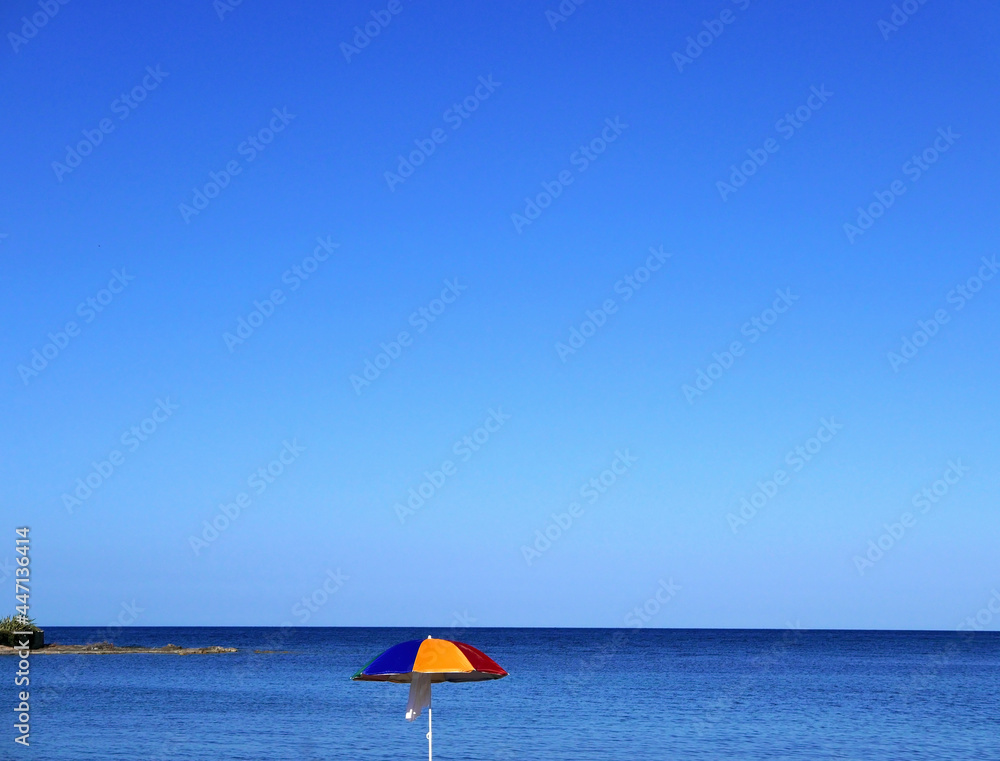 ombrellone colorato contro il cielo blu estivo