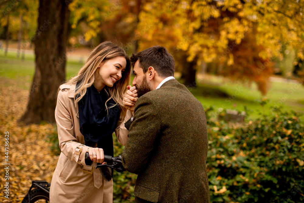 Young couple in the autumn park with electrical bicycle Young couple in the autumn park with electrical bicycle