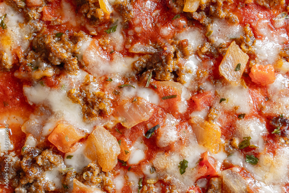 Macro close-up of a barbecued meat pizza.