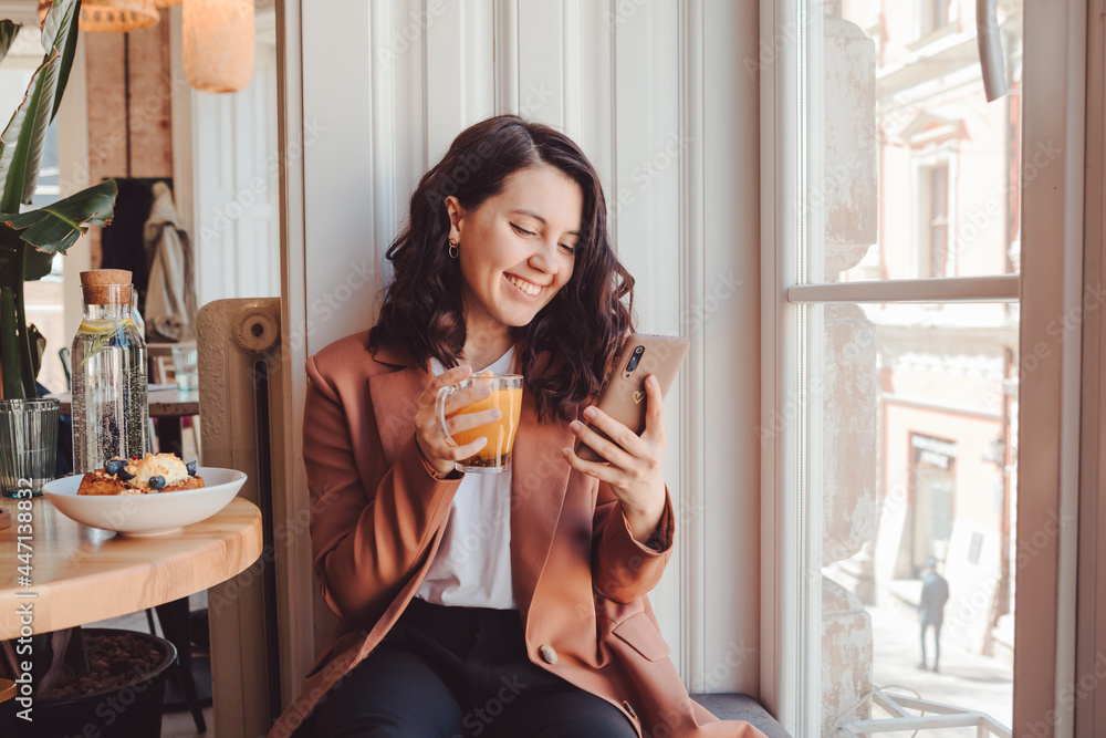 pretty woman in cafe eating and surfing internet on the phone pretty woman in cafe eating and surfing internet on the phone
