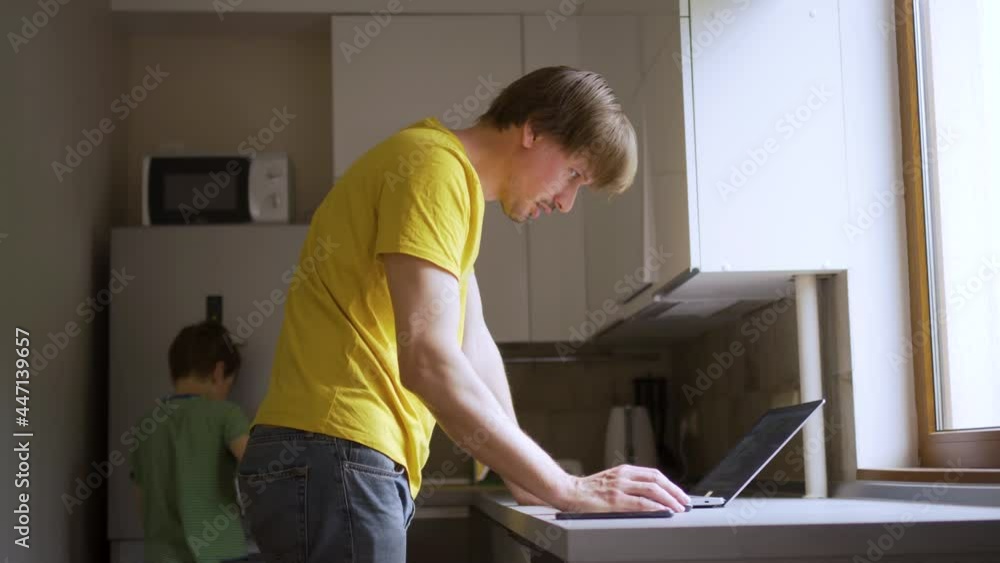 A man uses a laptop for distant work on a project. Work from home concept with children. A man uses a laptop for distant work on a project. Work from home concept with children.