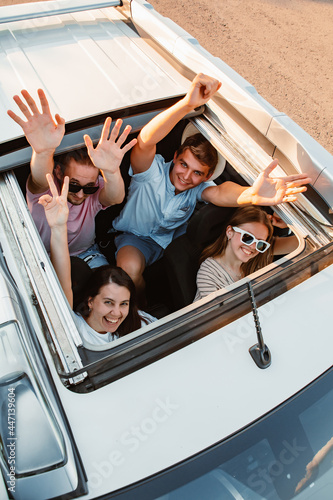Bild auf Leinwand group of friends in car looking up through sunroof