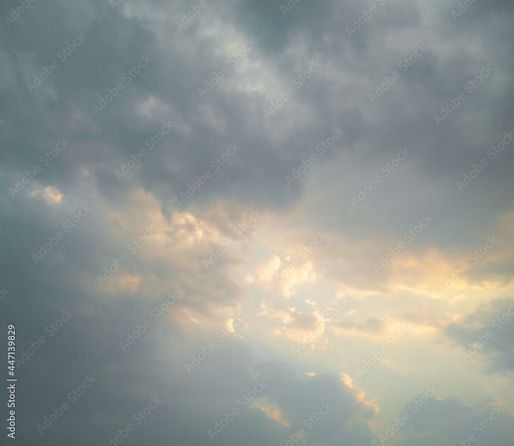 Dramatic weather, beautiful scenery, sun hiding behind clouds in blue sky background, nature photography
