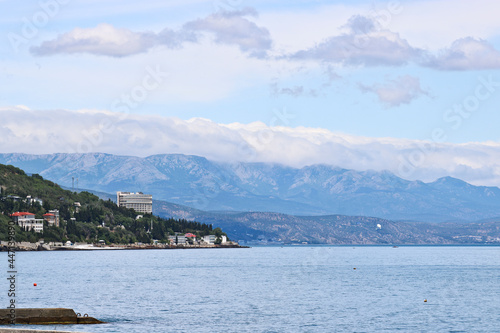 View from the sea to Alushta, Crimea. The Black Sea and blue mountains in the distance - a calm summer landscape.