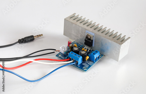 Diy mini power amplifier board with power supply on background.