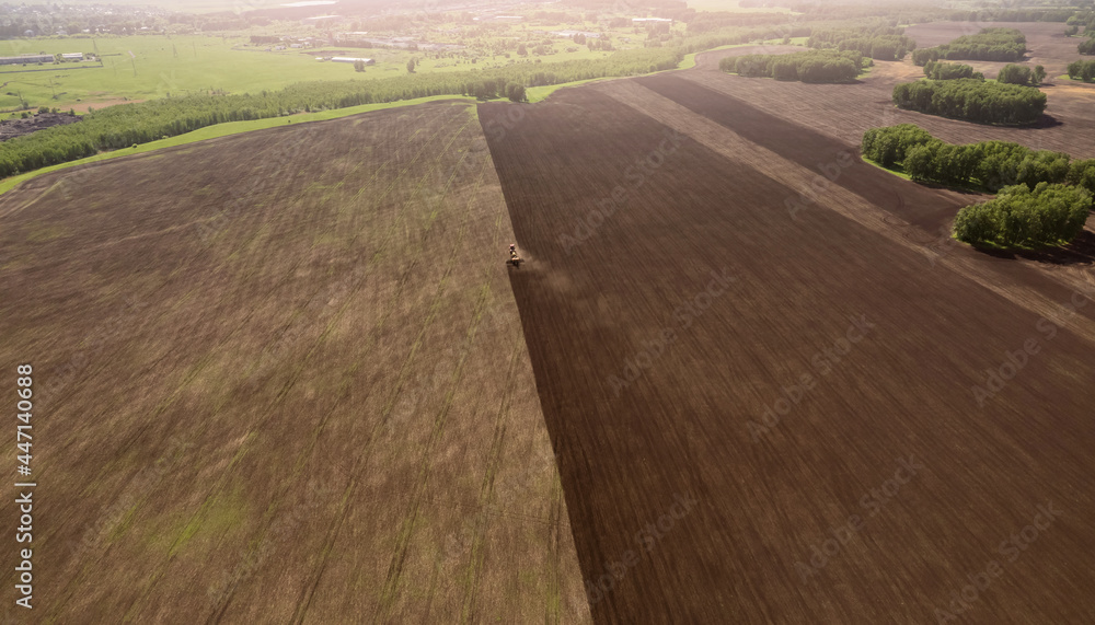 Agriculture Tractor cultivation and plows land of field for planting cereals plough, Aerial top view rural