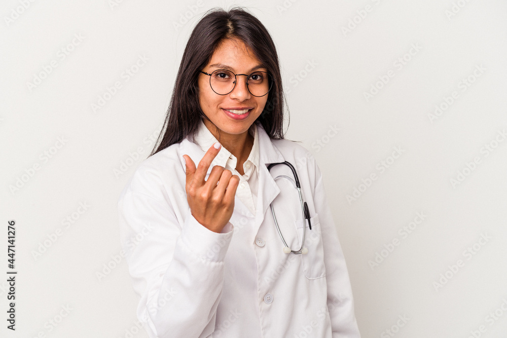 Young doctor latin woman isolated on white background pointing with finger at you as if inviting come closer. Young doctor latin woman isolated on white background pointing with finger at you as if inviting come closer.