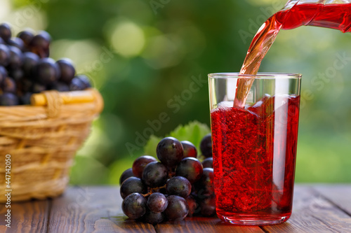 Murais de parede grape juice pouring into glass from jug