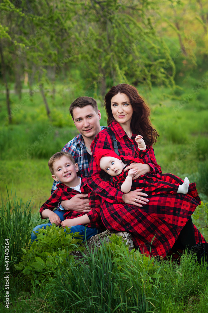 Happy family spend time together outside in green nature. International family day concept. Family look. Real people Happy family spend time together outside in green nature. International family day concept. Family look. Real people