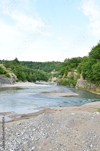 River Mat with canyon, gravel bed and trees with blue sky in summer near Burrel in Albania