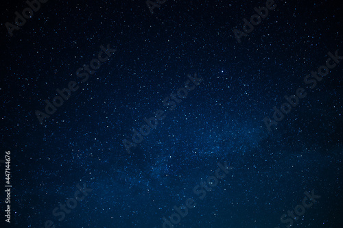 Night starry sky. Milky Way. Many stars twinkle in the dark blue sky. Minimalism. There are no people in the photo. Background. Texture. Wallpaper.
