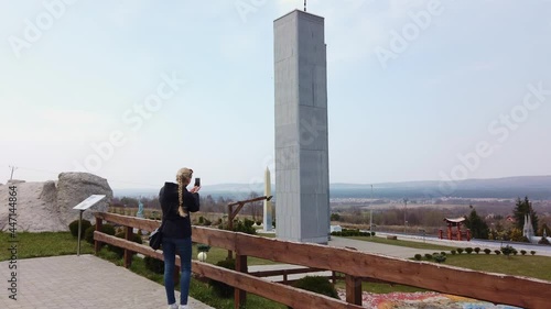 A steady shot of Female makes photo walking on foot near a miniature model of the World Trade Center, New York City. Park of Miniatures. Kielce, Poland - April 1, 2019.