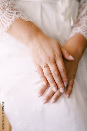 Bride in white dress folded her hands in her lap