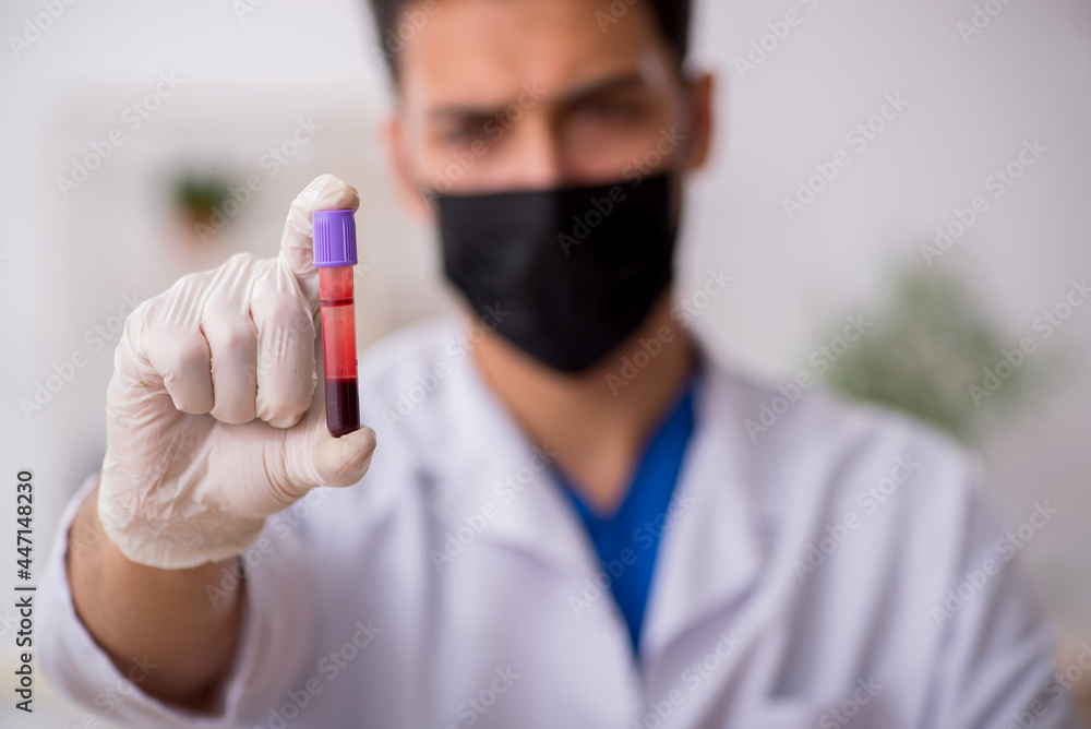Young male chemist in pandemic concept Young male chemist in pandemic concept