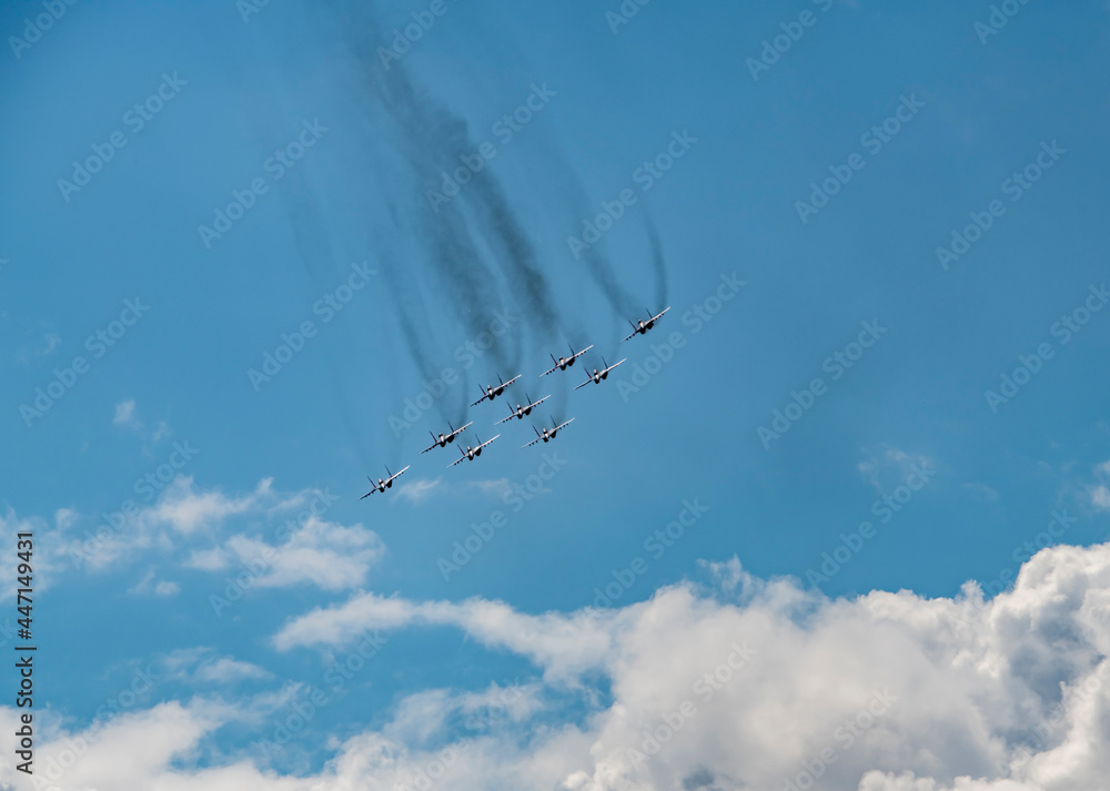 nine combat aircraft perform complex aerobatics against the sky 