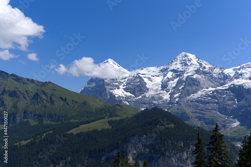 Mountain peaks Eiger and Mönch (Monk) at Bernese highland on a sunny summer day with blue sky background. Photo taken July 20th, 2021, Lauterbrunnen, Switzerland.