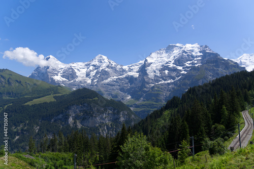 Mountain peaks Eiger, Mönch (Monk) and Jungfrau (Vrigin) at Bernese highland on a sunny summer day with blue sky background. Photo taken July 20th, 2021, Lauterbrunnen, Switzerland.