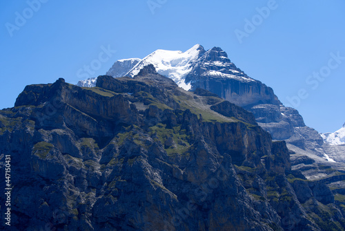 Mountain peak Jungfrau (Virgin) at Bernese highland on a sunny summer day with blue sky background. Photo taken July 20th, 2021, Lauterbrunnen, Switzerland.