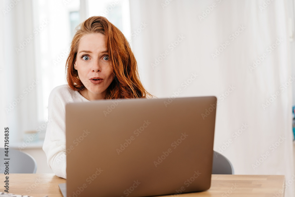 Young woman staring wide-eyed at camera in astonishment Young woman staring wide-eyed at camera in astonishment