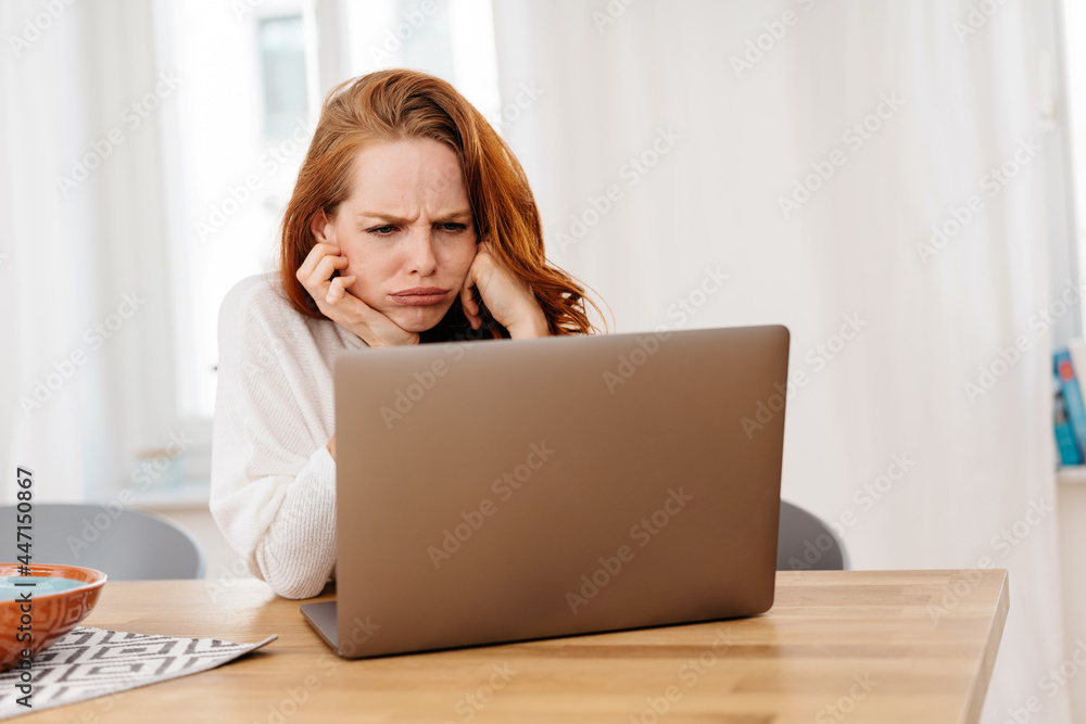 Frustrated or confused young woman frowning at her laptop Frustrated or confused young woman frowning at her laptop