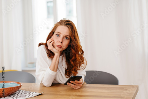 Fotografia Glum despondent young woman waiting for a phone call