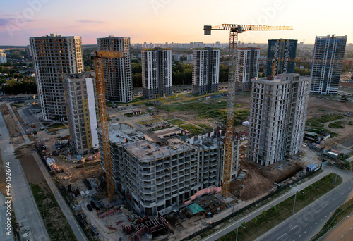 Tower crane on construction site on sunset background. Arial view of the cranes the conctruct the high-rise building. Construction and the built environment. Pouring concrete into the formwork photo