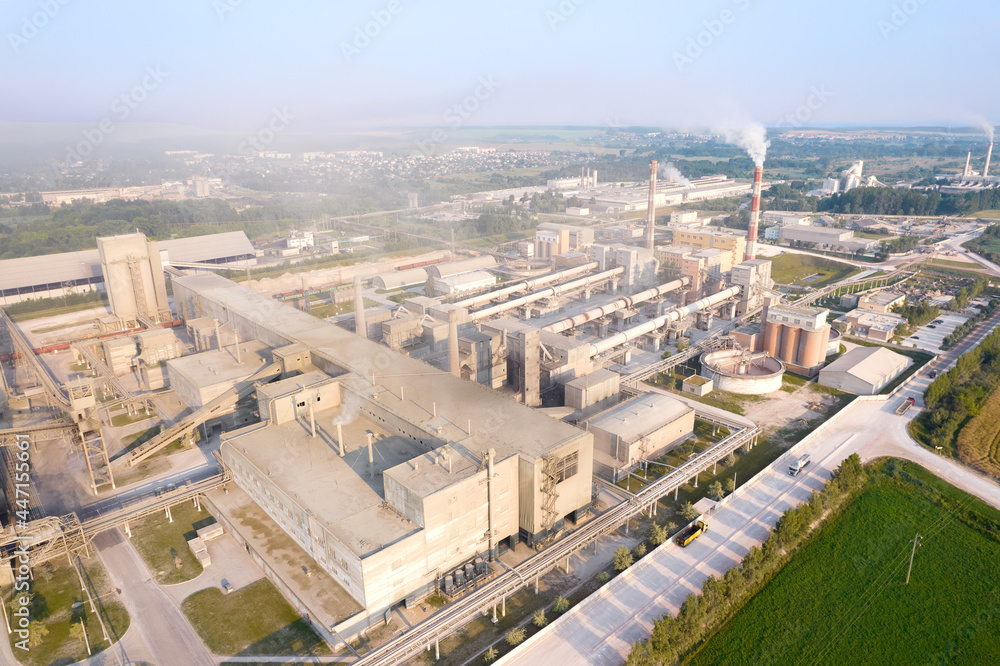 View of the cement plant with pipes. Industrial factory with smoke frow pipe. Chimney smokestack emission. Сement production process Ecology concept, air and environmental pollution View of the cement plant with pipes. Industrial factory with smoke frow pipe. Chimney smokestack emission. Сement production process Ecology concept, air and environmental pollution