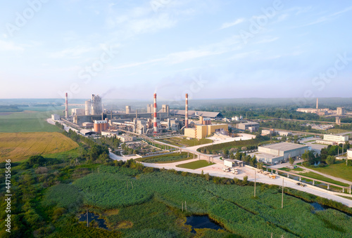 View of the cement plant with pipes. Industrial factory with smoke frow pipe. Chimney smokestack emission. Сement production process Ecology concept, air and environmental pollution