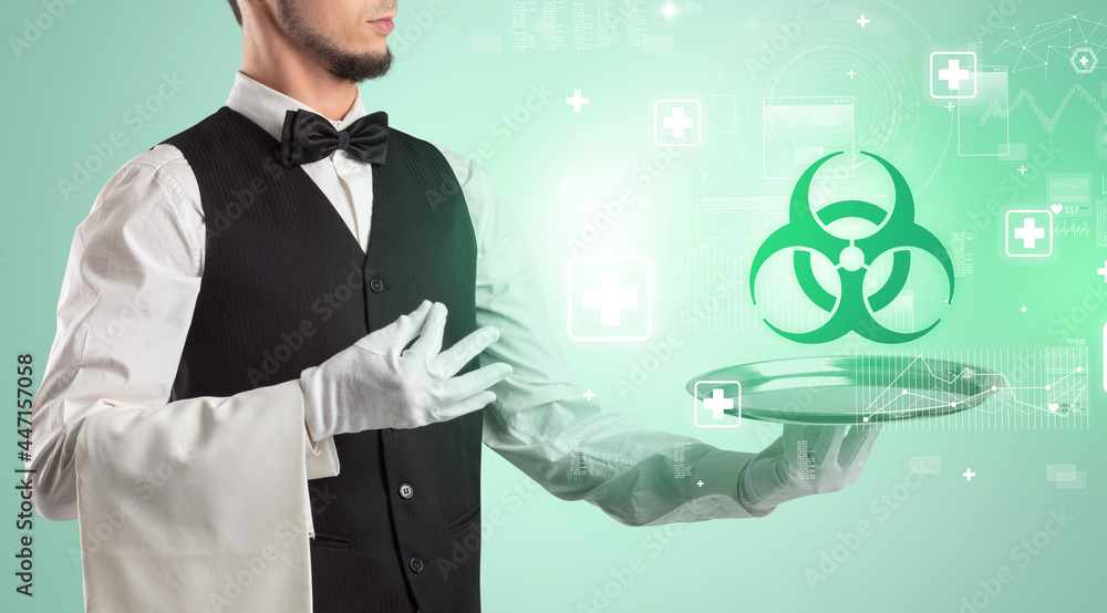 Handsome young waiter in tuxedo holding healthcare icons on tray Handsome young waiter in tuxedo holding healthcare icons on tray